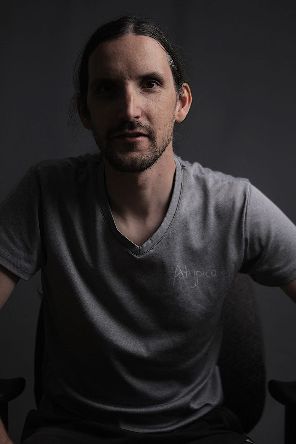 Professional moody portrait of Augustin Delporte (Pragm) looking suspiciously like Peter McKinnon with long hair tied back. Shot in the Atypica studio in Griffintown, Montreal, Canada